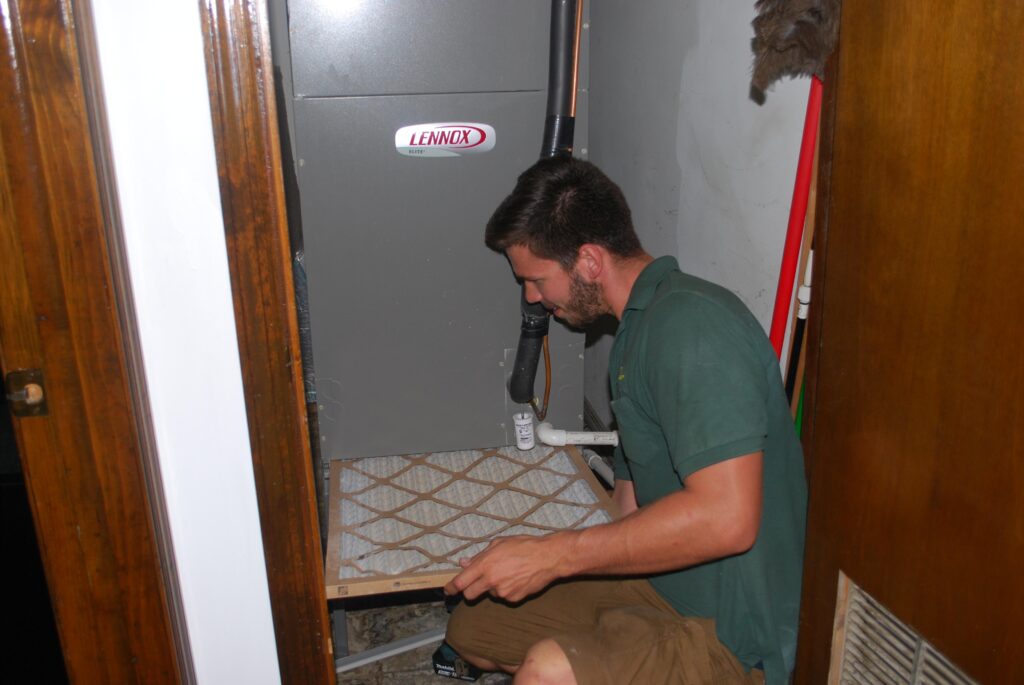 A technician pulling out an AC filter