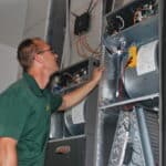 A technician checking the back end of the Air conditioner
