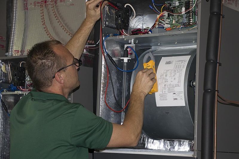 A technician tuning up air heating device