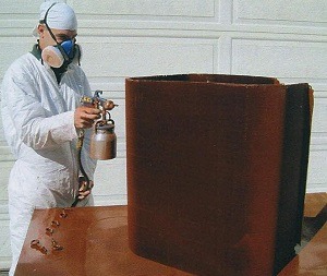 A specialist spraying anti-corrosion coating on metal